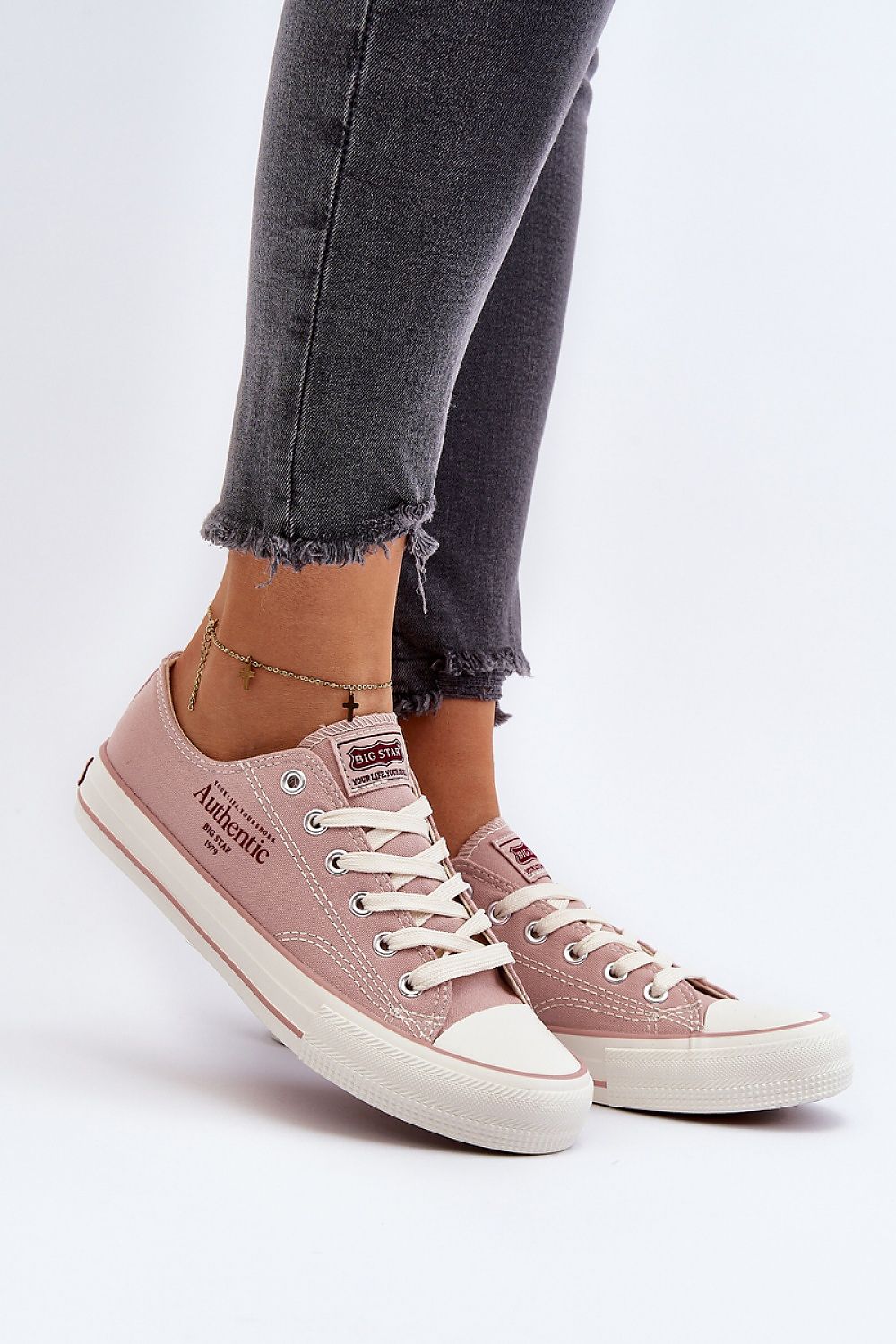 Sneakers rosa Big Star in tessuto con suola bianca e dettagli testuali, indossate con jeans grigi sfrangiati e cavigliera dorata 194990 Step in style