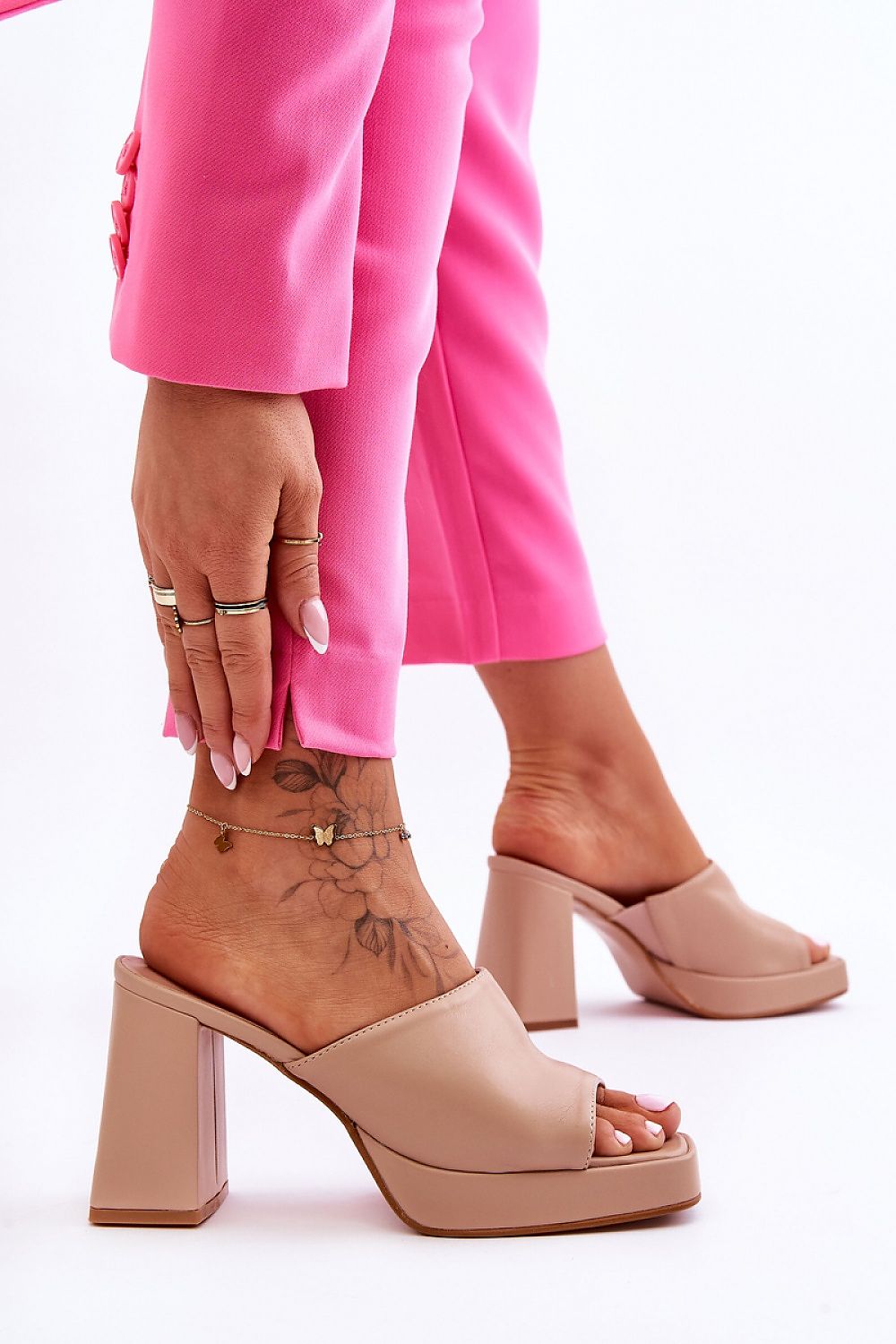  ciabatte model 181070 Dettaglio delle ciabatte con zeppa in ecopelle color nude, con mano che tocca il bordo