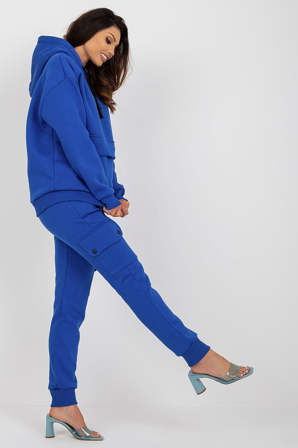  Factory Price  186183  Vista laterale del completo sportivo azzurro, mostra la vestibilità dei pantaloni cargo e la tasca sulla coscia.